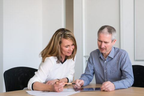 Eine Frau und ein Mann besprechen sich an einem Tisch