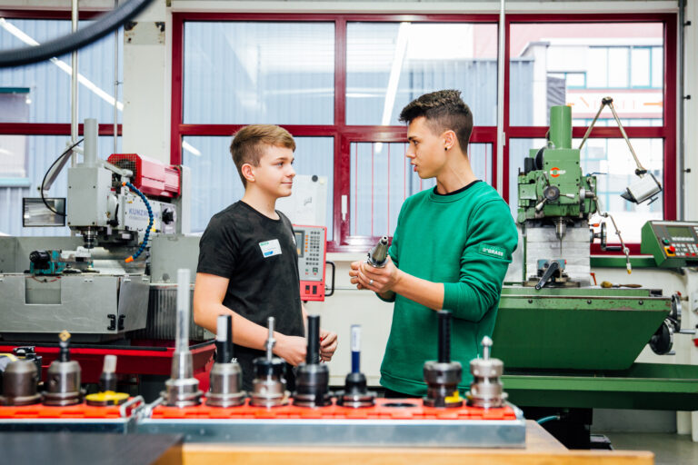 181115_WISTO_CHANCENTAGE_140_by_Weissengruber_Partner Ein Lehrling zeigt einem Praktikanten ein Werkstück