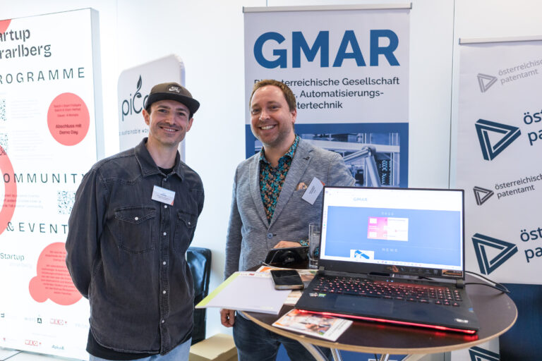 Zwei Personen auf INNOVATE VORARLBERG 2025 vor einem Roll-Up