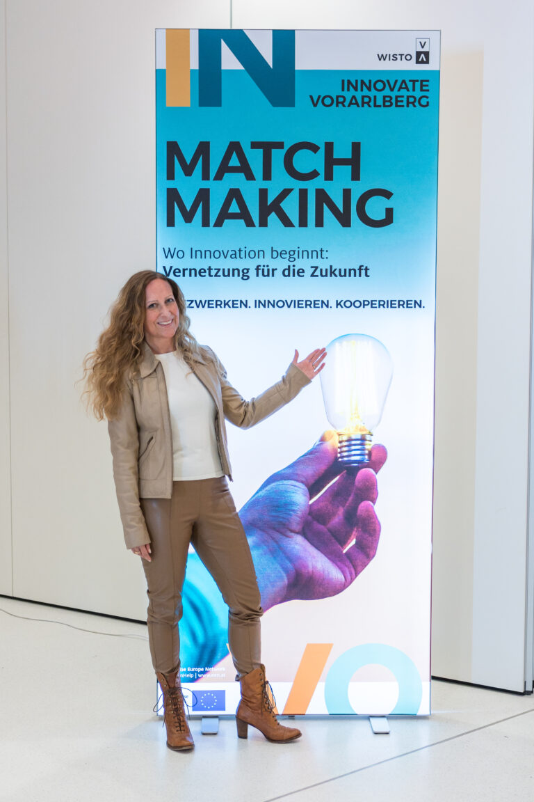 Frau steht vor einem LED-Banner mit dem Schriftzug MATCHMAKING