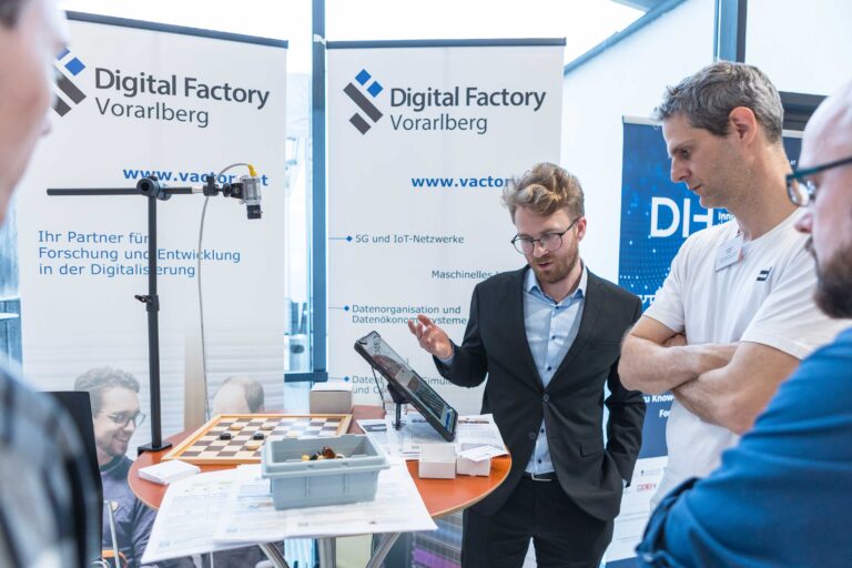 Besuchende bei der Innovate Vorarlberg informieren sich am Stand der Digital Factory Vorarlberg.