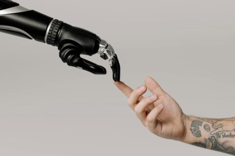 pexels-cottonbro-6153354 Roboterhand und Menschenhand berühren sich mit den Fingerspitzen